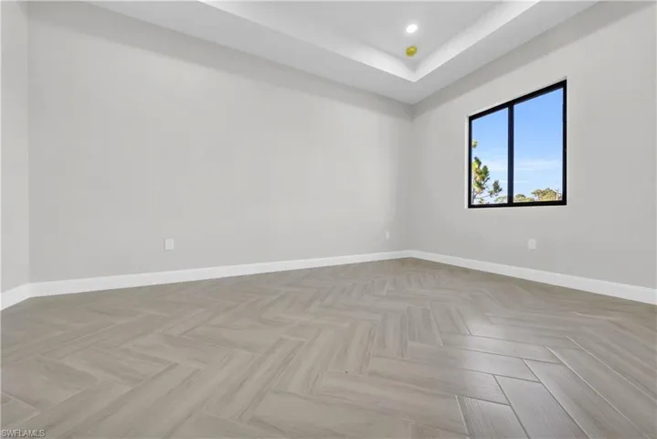 Unfurnished room featuring a tray ceiling and recessed lighting