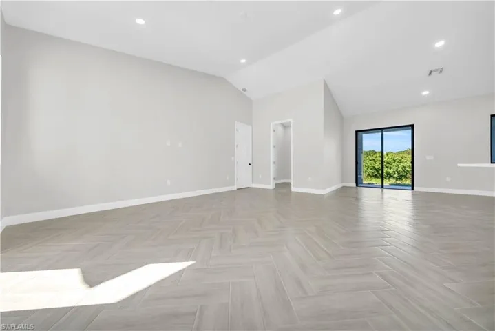 Spare room featuring recessed lighting and lofted ceiling