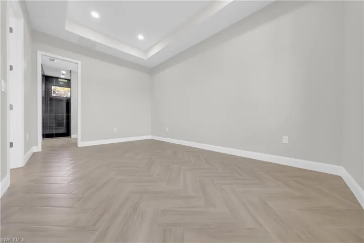 Spare room featuring a tray ceiling and recessed lighting