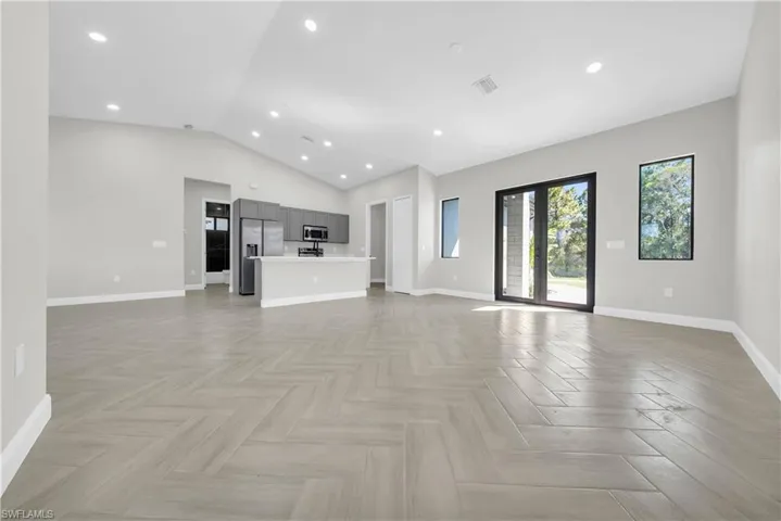 Unfurnished living room with recessed lighting and vaulted ceiling