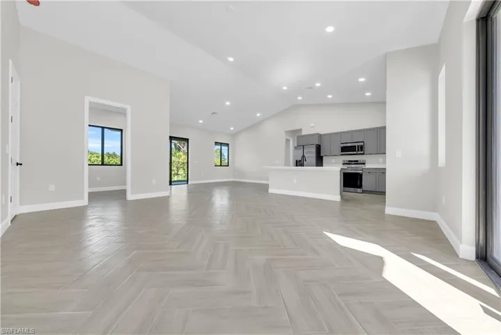 Unfurnished living room featuring recessed lighting and high vaulted ceiling