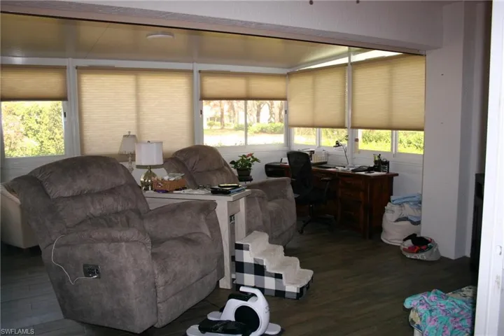 Sunroom with multiple windows, wood-finish flooring, and ample natural light