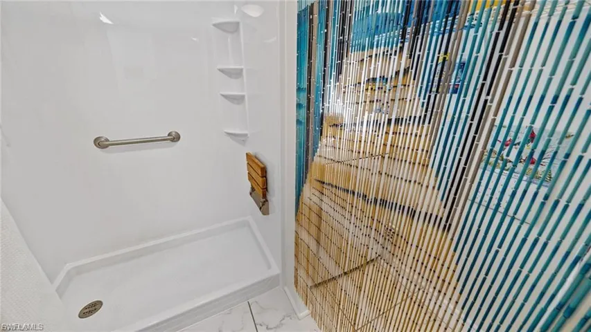 Gues Bathroom featuring a stall shower and marble look tiles