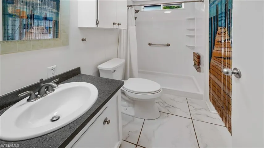 Bathroom featuring a shower stall and vanity