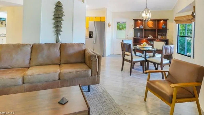 Living area with light wood finished floors and suspended lighting.