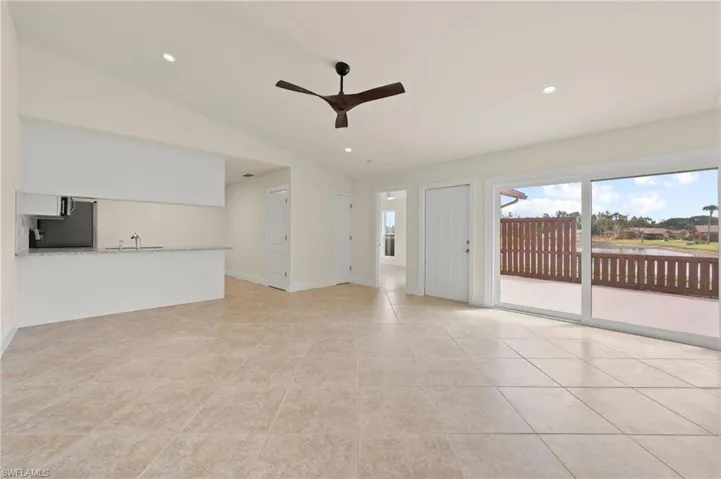 Unfurnished living room featuring a ceiling fan, lofted ceiling, healthy amount of natural light, recessed lighting, and light tile patterned floors