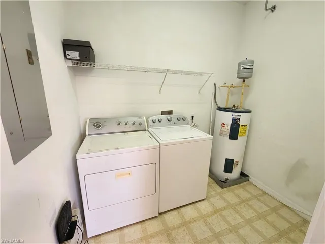 Laundry area featuring washing machine and clothes dryer, water heater, and electric panel