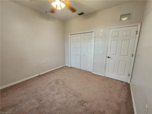 Unfurnished bedroom featuring ceiling fan, a closet, and carpet