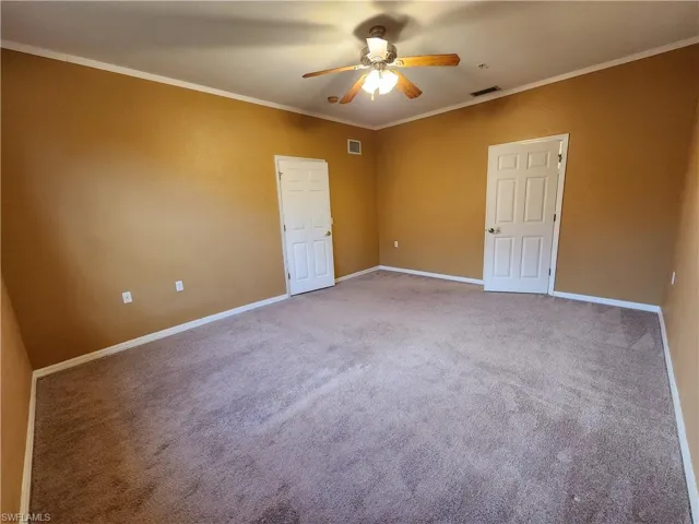 Spare room with ornamental molding, carpet, and ceiling fan