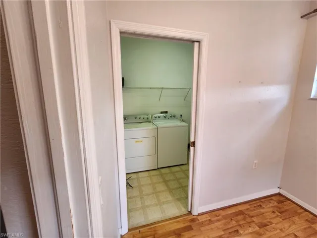 Clothes washing area featuring separate washer and dryer and light hardwood / wood-style flooring