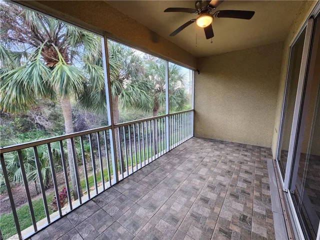 Unfurnished sunroom featuring ceiling fan
