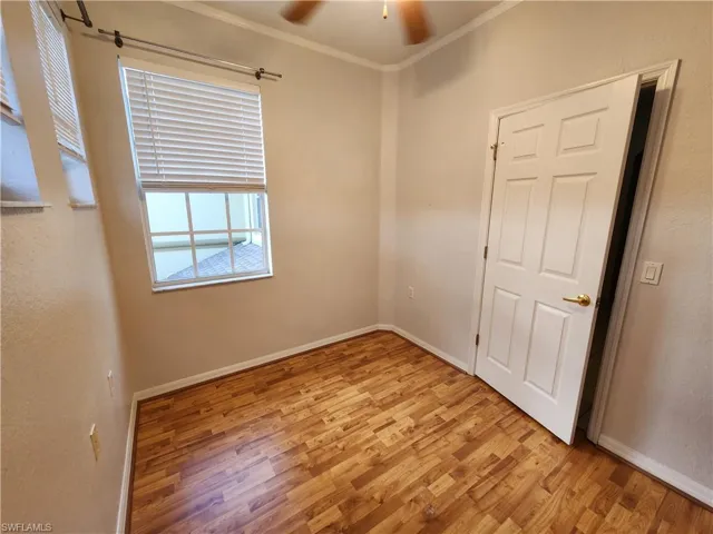 Empty room with light hardwood / wood-style flooring, ceiling fan, and crown molding