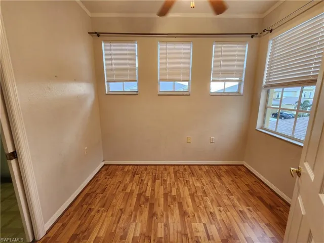 Empty room with ornamental molding, light hardwood / wood-style floors, and ceiling fan