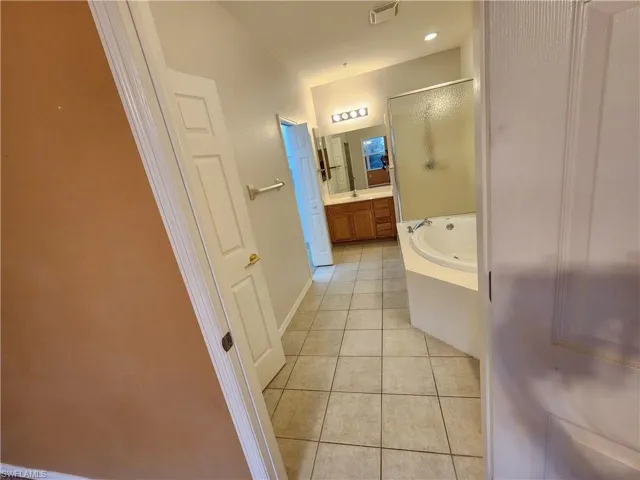 Bathroom featuring vanity, tile patterned floors, and plus walk in shower