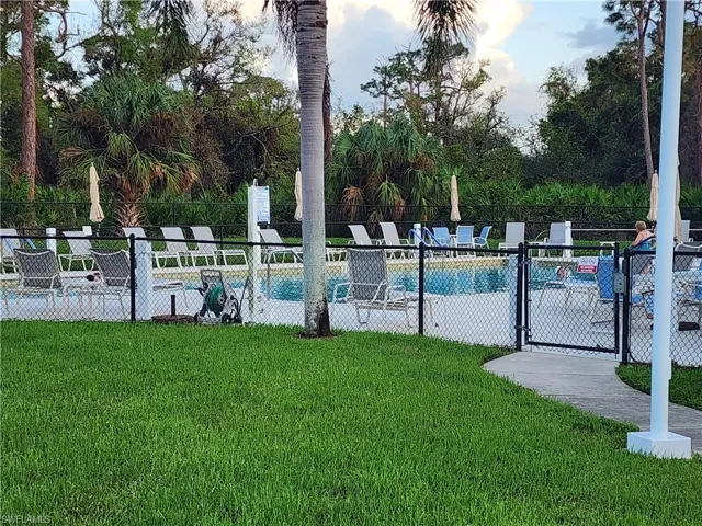 View of pool with a lawn