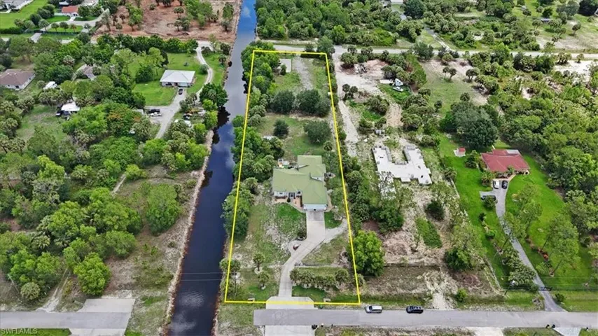 Aerial view of property and surrounding area with a large body of water and property parcel outlined
