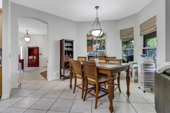 Dining space with arched walkways and light tile patterned flooring