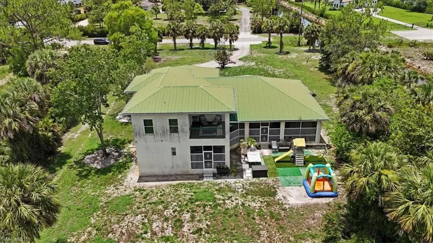 Back of house with a sunroom, stucco siding, and a metal roof