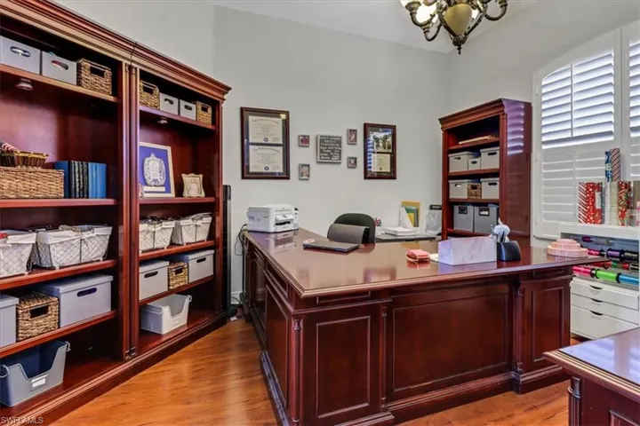Office area featuring a chandelier and wood finished floors
