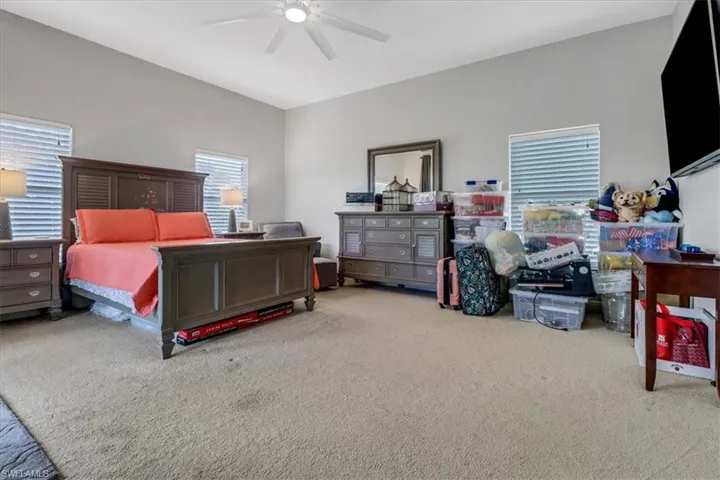 Carpeted bedroom with a ceiling fan
