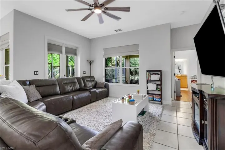 Living room featuring a ceiling fan and light tile patterned floors
