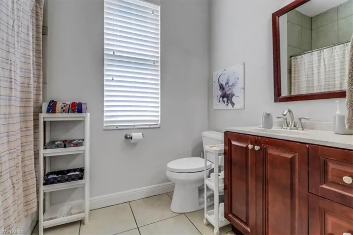 Full bath with tile patterned floors, vanity, and a shower with curtain