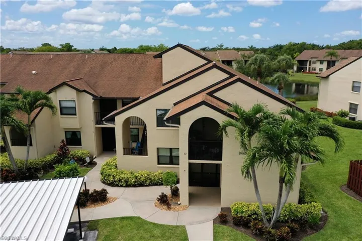 View of front of property with stucco siding, a front lawn, and a water view