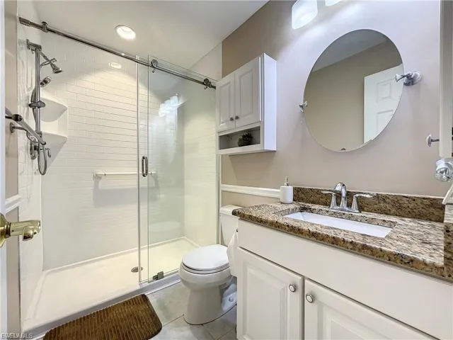 Full bathroom featuring vanity, a shower stall, and light tile patterned floors