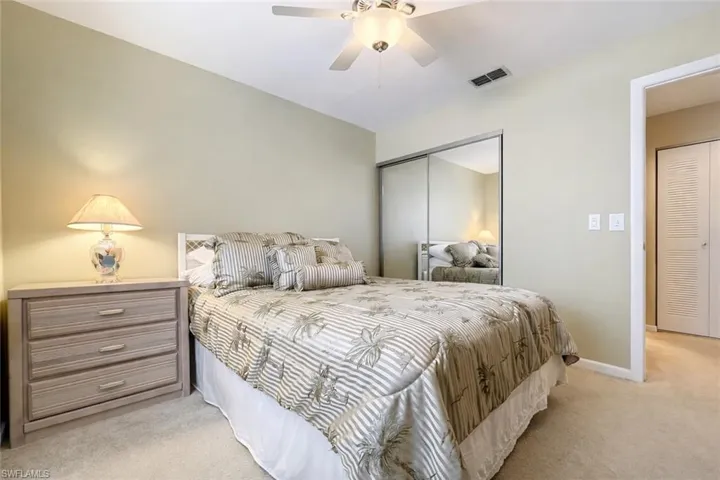 Bedroom with light carpet, a closet, and ceiling fan