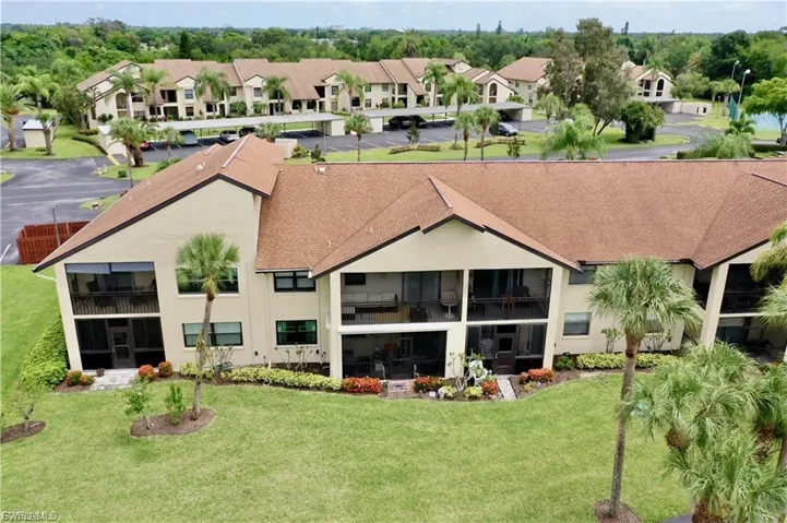 Rear view of property with roof with shingles, stucco siding, and a yard