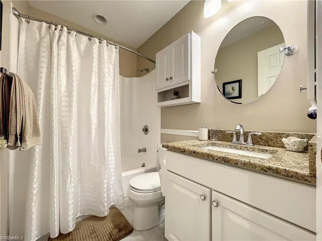 Bathroom featuring vanity and shower / bath combo with shower curtain