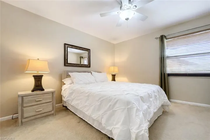 Bedroom with light carpet and a ceiling fan