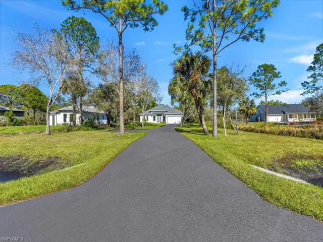 View of front of property with a front yard  and a 2 cars detached garage.