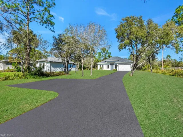 Ranch-style house featuring a 2 cars detached garage and a front lawn