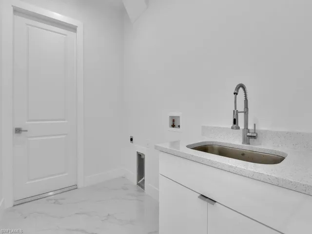 Laundry room featuring hookup for an electric dryer, cabinets, sink, and hookup for a washing machine