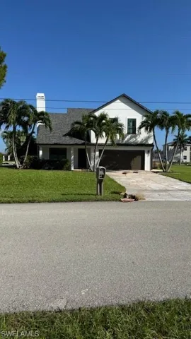 View of front facade with concrete driveway, a front lawn, and an attached garage