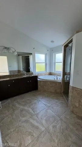Bathroom featuring a bath, vanity, and a shower stall