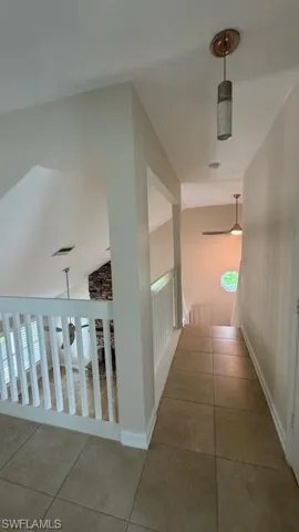 Hall with tile patterned floors and lofted ceiling