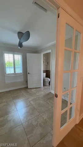 Hallway featuring crown molding and light tile patterned floors