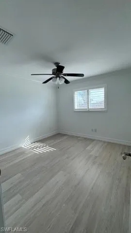 Unfurnished room featuring light wood finished floors, a textured ceiling, and crown molding