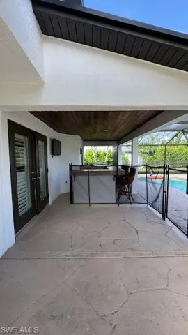 View of patio featuring a lanai