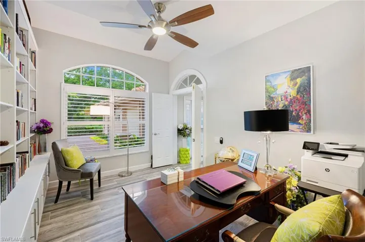 Living room with light hardwood / wood-style floors, lofted ceiling, and ceiling fan