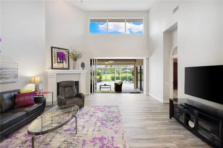 Living room with wood-type flooring and a high ceiling