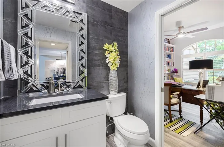 Bathroom featuring tile walls, hardwood / wood-style flooring, toilet, and vanity