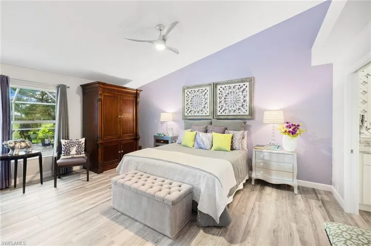 Bedroom with vaulted ceiling, ceiling fan, and light wood-type flooring