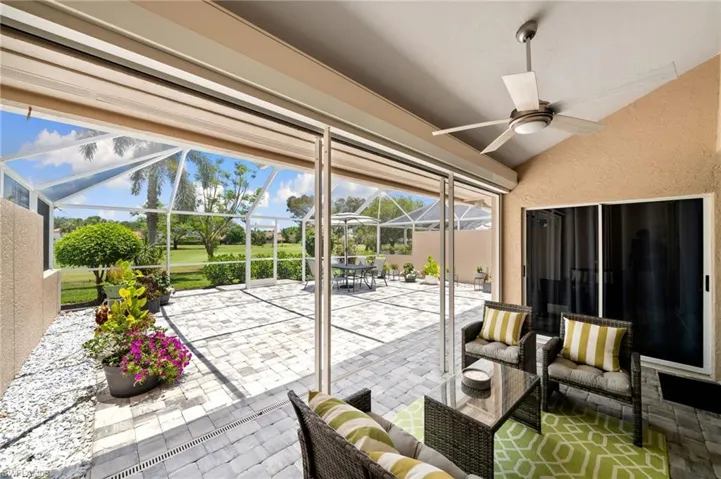 View of patio with glass enclosure and ceiling fan