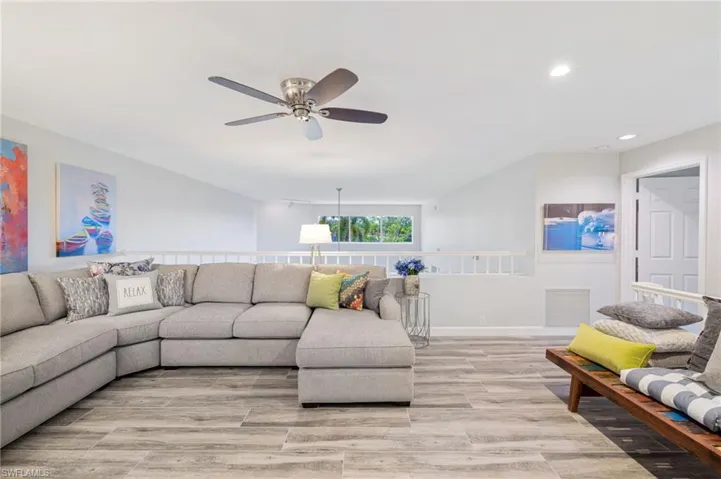 Living room with light hardwood / wood-style floors and ceiling fan