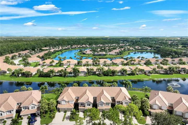 Aerial perspective showcasing a residential community with multiple water features, mature landscaping, and uniform architectural styles