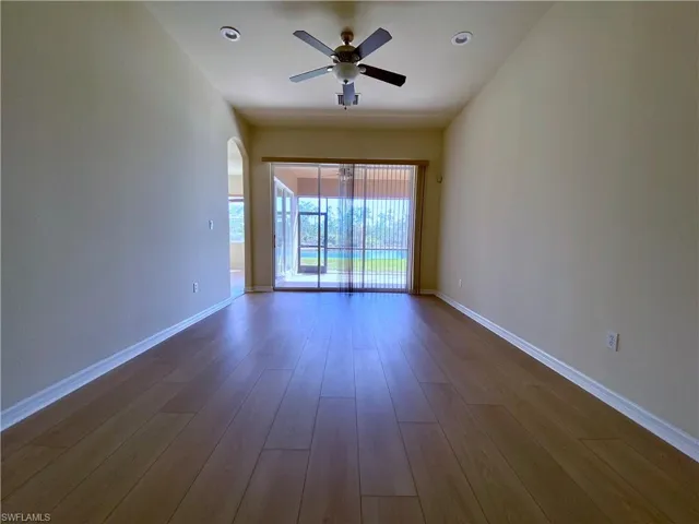 Spare room with wood finished floors, arched walkways, a ceiling fan, and recessed lighting