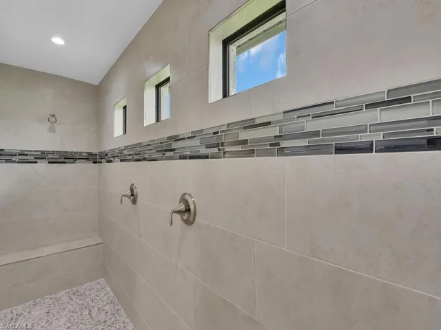 Bathroom featuring a tile shower and a wealth of natural light